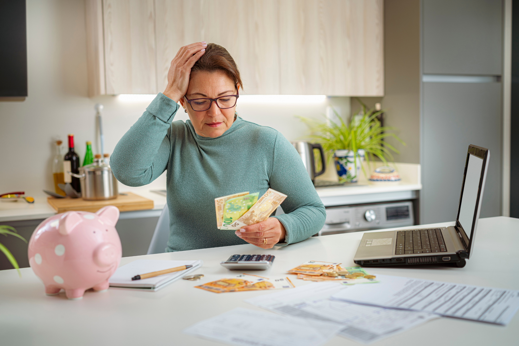The stress and frustration of financial struggles, as a woman examines her cash with concern, highlighting the impact of limiting money beliefs and the need for a mindset shift towards financial empowerment.